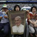 A woman held a picture of Pope Francis as the crowd waited for his arrival to attend a Mass on Friday.