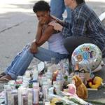 A relative of Nazair Nunes-Escobar sat at a sidewalk memorial in Brockton.