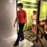 Jennifer Sullivan, who has lost more than 70 pounds, tries out an interactive walking display at the Museum of Science.