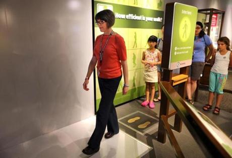 Jennifer Sullivan, who has lost more than 70 pounds, tries out an interactive walking display at the Museum of Science.
