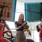 Sophia Spungin, 13 (center), taught violin to Angelina and Vanessa, both 10, who are homeless. Spungin and Emily Swearingen, 13, fund-raised to get the homeless girls violins of their own.