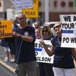 Supporters of Officer Darren Wilson held placards outside a St. Louis pub during a rally Saturday.