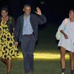President Obama and first lady Michelle Obama (left) walk with their daughter Malia across the South Lawn of the White House on Sunday night.