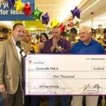 Stop & Shop New England president Joe Kelley (left) presents a check to Somerville YMCA executive director William Murphy at a Stop & Shop 100th anniversary event. 