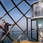 David Waller surveyed the lantern room, a glassed-in area atop the Graves Island Light Station, early this month. (Wendy Maeda/Globe Staff) 