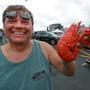 Clayton Witham is called for holding ? one of the many lobsters he and his family cooked in a Gillette Stadium parking lot. Jim Davis/Globe Staff