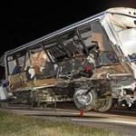 A wrecker removes the team bus from Interstate 35 in Davis, Okla., early Saturday,