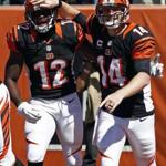 Cincinnati Bengals quarterback Andy Dalton (14) celebrates with wide receiver Mohamed Sanu (12) after Dalton scored on an 18-yard pass reception from Sanu in the first half of an NFL football game against the Tennessee Titans, Sunday, Sept. 21, 2014, in Cincinnati. (AP Photo/David Kohl)