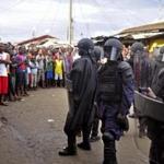 Liberian security officers in riot gear approached a crowd in the West Point area of Monrovia during an Ebola quarantine in August in Liberia.