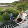 Residents fit solar thermal water heaters onto a cottage on the island of Eigg, Inner Hebrides, Scotland. Almost all of the energy on Eigg comes from renewable resources.