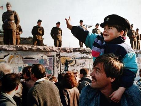 A boy waved to soldiers on the Berlin Wall in front of the Brandenburg Gate on Nov. 10, 1989, the day after the wall fell.
