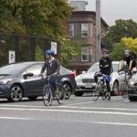 Bicyclists at the corner of Somerville Avenue and Beacon Street wait for the green light.