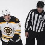 The Bruins' Milan Lucic is escorted off the ice by linesman Michel Cormier after receiving a penalty at 18:40 of the third period.  (AP Photo/The Canadian Press, Paul Chiasson)