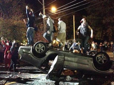 People jumped on a flipped car in Keene, N.H.
