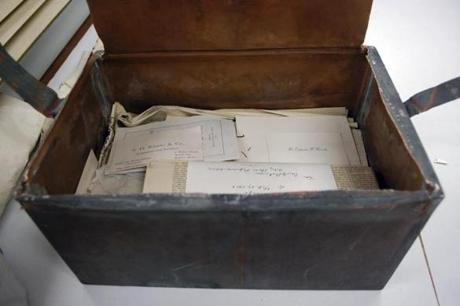 Items stacked inside a shoebox-sized 1901 time capsule.
