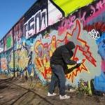 Artists worked at the Clemenzi Industrial Park in Beverly. Since people began spraypainting the wall a decade ago, the drawing of graffiti has fallen elsewhere in the city.