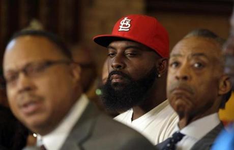 Michael Brown Sr. (center) stood next to the Rev. Al Sharpton at a press conference Tuesday in St. Louis.
