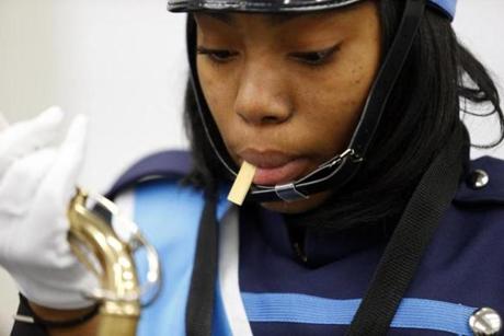 Nia Richardson, 16, of Roxbury, wets the reed of her saxophone as she prepares for practice in Jamaica Plain Nov. 19. 
