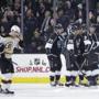 Los Angeles Kings players celebrate a goal by Tanner Pearson (70) as Boston Bruins' Simon Gagne, left, skates toward the bench during the first period of an NHL hockey game Tuesday, Dec. 2, 2014, in Los Angeles. (AP Photo/Jae C. Hong)