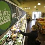 In this March 27, 2014, photo, a woman shops at the Whole Foods Market in Woodmere Village, Ohio. Whole Foods reports quarterly financial results on Wednesday, July 30, 2014. (AP Photo/Tony Dejak)