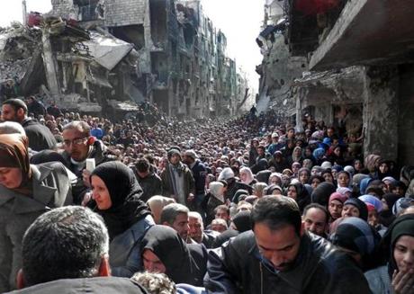 Residents of the besieged Palestinian camp of Yarmouk queuing to receive food supplies in Damascus, Syria, in a photo taken Jan. 31, 2014.
