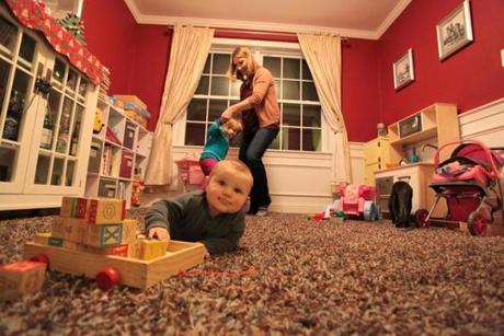 Kate Lynde plays with her children Aria, 3, and Coen, 8 months, in the dining room of their Tewksbury home. 
