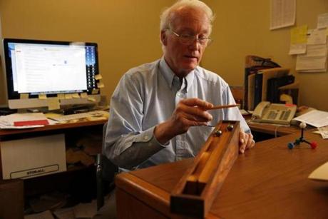 T. Ross Kelly, an organic chemistry professor at Boston College, demonstrates a physics-related gizmo in his Chestnut Hill office, which is filled with toys and other curiosities that he uses to demonstrate scientific principles. 
