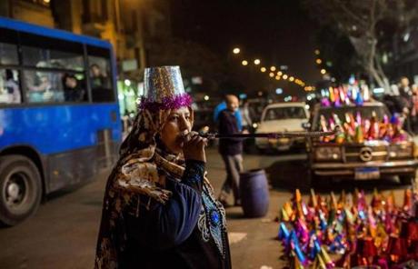 A woman blew on a noisemaker in Cairo.
