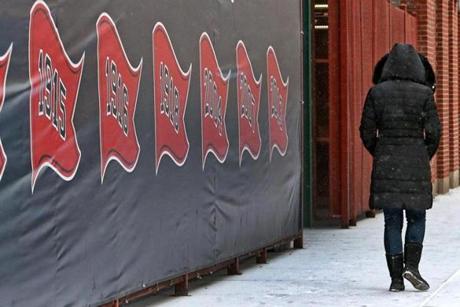 A pedestrian bundled up against winter walked along Van Ness Street outside of Fenway Park.
