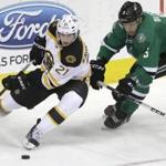 Boston Bruins left wing Loui Eriksson (21) and Dallas Stars defenseman Jamie Oleksiak (5) skate for the puck during the second period of an NHL hockey game Tuesday, Jan. 20, 2015, in Dallas. (AP Photo/LM Otero) 