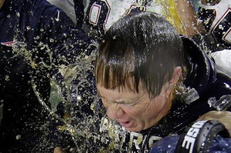 New England Patriots head coach Bill Belichick is doused by sports drink after NFL Super Bowl XLIX football game against the Seattle Seahawks Sunday, Feb. 1, 2015, in Glendale, Ariz. The Patriots won 28-24. (AP Photo/Matt Slocum) 
