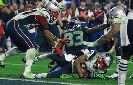 Malcolm Butler falls to the turf after his interception that gave the Patriots the win Sunday.
