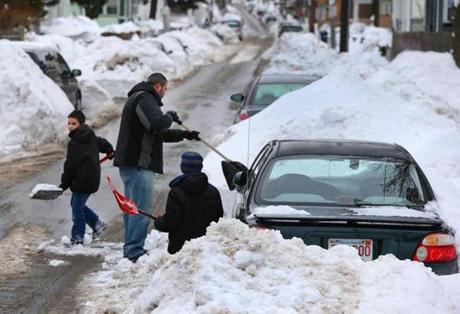 Angel Cruz and his sons Christian left, and Emanuel shoveled out their car on Hutchings Street in Boston Saturday.
