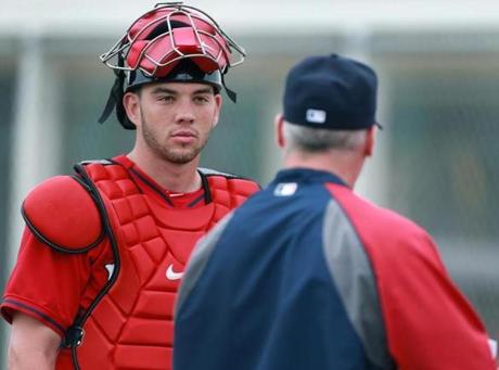 02/25/14: Ft. Myers, FL: FOR POSSIBLE USE WITH BASEBALL PREVIEW SECTION.........Red Sox catching prospects Blake Swihart (left), and Christian Vazquez (right) are pictured talking to bullpen coach Dana LeVangie (center). (Jim Davis/Globe Staff) section:sports topic:Red Sox Spring Training
