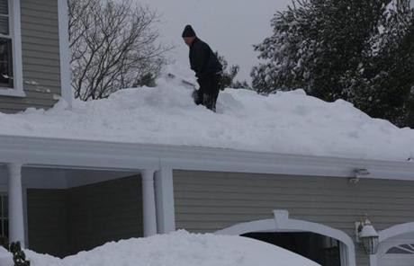 Francis Collins shoveled snow off the roof of his Hingham home.
