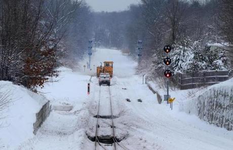 Crews worked to remove snow from MBTA commuter rail tracks in Scituate.

