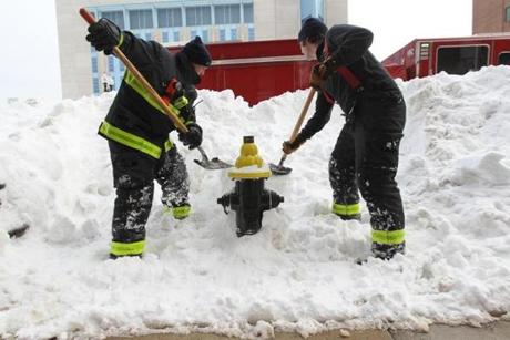 Firefighters from Engine 3 work to dig out a fire hydrant on Albany Street.

