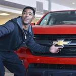 New England Patriots cornerback Malcolm Butler poses with a Chevrolet pickup truck he was presented Tuesday, Feb. 10, 2015, at a dealership in Norwood, Mass. The truck was intended to go to Patriots quarterback Tom Brady as Super Bowl Most Valuable Player. But Brady and the automaker determined that Butler should receive it in recognition for his game-saving interception that clinched the team's Super Bowl XLIX victory. (AP Photo/Josh Reynolds) 