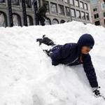  Quinlan O?Malley, 9, and his brother, Mason, 5, (top) of Newton slid down the giant snowbanks lining Quincy Market on Tuesday.
