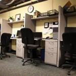 Empty cubicles, as at Boston Business Printing on Tuesday in Boston, place a strain on businesses. Jessica Rinaldi/Globe Staff 