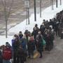 Commuters waited in a line that snaked from the parking lot through the Wollaston T station to board Red Line shuttle buses on Wednesday.