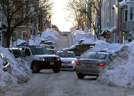 Vehicles maneuvered down a narrow street in South Boston. 
