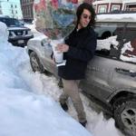 Stapleton Florist employee Danny Jose trekked over snow on East 7th St. in South Boston to make a delivery on Friday. 