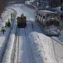 Shovelers dug out MBTA tracks as a commuter rail train passed by. 