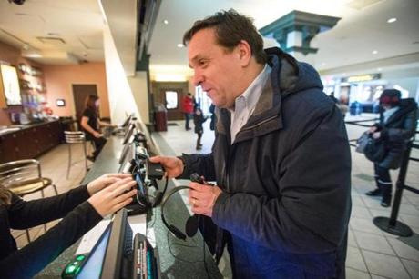Carl Richardson and his service dog enter AMC Loews Boston Common Theater to take in ?American Sniper.? Richardson received a special hearing device to enjoy the film.
