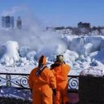 Sightseers took pictures of a nearly frozen Niagara Falls on Friday. 
