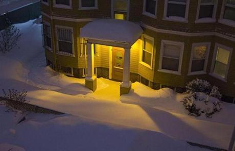 A light illuminates the snow during the night.
