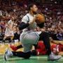 Jared Sullinger gathers in the ball in front of fallen Miami Heat's Hassan Whiteside during the first half of an NBA basketball game in Boston, Sunday, Feb. 1, 2015. (AP Photo/Winslow Townson)