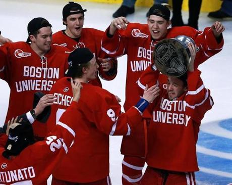 Boston University's Cason Hohmann hoisted the Beanpot first as he skated to his celebrating teammates.
