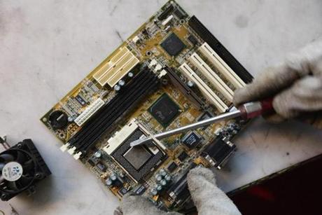 A worker stripped down a circuit board at a recycling company in Berlin. Computers, among other devices, depend on some of Earth?s rarest metals.
